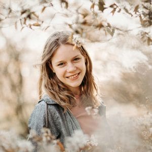 foto van een lachende meisje tussen de lente bloemetjes tijdens portret fotoshoot in Blaricum